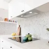 A modern kitchen countertop with an induction stovetop, cookware, and a backsplash. Voir les images du produit