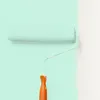 A paint roller is shown applying mint green paint to a white wall. Produktbild-Vorschau