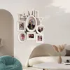 A white multi-photo frame collage with the word 'FAMILY' above it, mounted on a light gray wall in a living room setting. A beige sofa and a turquoise beanbag chair are visible in the foreground. Produktbild-Vorschau