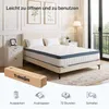 A bedroom scene featuring a mattress on a bed, with a mattress box and instructional icons in the foreground. Náhled obrázku produktu