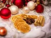 Christmas ornaments and dried fruit slices arranged on a sparkly white surface. Podgląd zdjęcia produktu