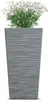 A tall, grey, textured planter with white flowers growing out of it, set against a white background. Voir les images du produit
