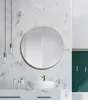 A modern bathroom with a marble-patterned wall, a round gold-framed mirror, a white vessel sink with a gold faucet, and hanging pendant lights. Náhled obrázku produktu