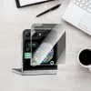 A Samsung Galaxy Z Flip phone with a screen protector applied, placed on a wooden desk next to a notebook, pen, laptop, and coffee cup. Anteprima dell’immagine prodotto