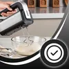 A hand holding a mixer over a bowl of dough. Produktbild-Vorschau
