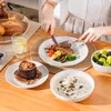 A table setting with a meal, including meat, vegetables, dessert, soup, and fruit salad. Náhled obrázku produktu