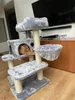 An orange cat is relaxing on a multi-level cat tree in a living room setting. Náhled obrázku produktu