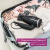 A black and gold travel hair dryer is packed inside an open suitcase with clothes. Podgląd zdjęcia produktu