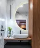 A modern bathroom vanity with a round LED mirror, a vessel sink, and wooden cabinetry. Produktbild-Vorschau