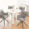 A round white dining table with four grey chairs in a bright room. Voir les images du produit