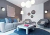 A modern living room with a sofa, chairs, coffee table, and decorative wall art. Podgląd zdjęcia produktu