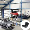 Schwarzes ergonomisches Sitzkissen mit blauen Akzenten und Luftstrompfeilen, gezeigt in einem kreisförmigen Ausschnitt über einer Autowerkstattszene Náhľad obrázku produktu
