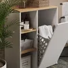A close-up view of a bathroom cabinet with open shelves and a laundry basket, showcasing storage solutions. Náhled obrázku produktu