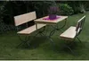 A wooden picnic table and benches set in a garden setting. Náhled obrázku produktu