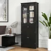 A black freestanding cabinet with glass doors and shelves, placed in a room next to a sofa and a plant. Voir les images du produit