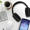 A desk setup with headphones, a keyboard, a mouse, a cup of coffee, and a smartphone. Produktbild-Vorschau