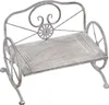 A decorative metal bench, possibly for a garden or dollhouse, with a distressed gray finish and wheel accents. Produktbild-Vorschau