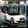 A white electric toy car is shown in front of charging stations, with various text overlays and measurements. Produktbild-Vorschau