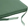 A close-up view of a green cushion with attached straps. Produktbild-Vorschau