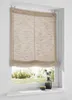 A Roman blind is installed on a window, with a view of greenery outside. A small vase with dried flowers and a bowl are on the windowsill. Produktbild-Vorschau