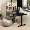 A woman is sitting on a stability ball and working on a laptop at a standing desk in a home office setting. Náhľad obrázku produktu