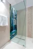 A modern bathroom with a glass shower enclosure featuring a scenic waterfall mural. Produktbild-Vorschau