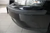 A close-up view of the front bumper and headlight of a black car. Produktbild-Vorschau