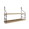 A two-tiered wooden shelf with black metal ornate supports, shown against a white background. Náhled obrázku produktu