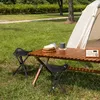 A camping scene with a table, chairs, tent, and radio. Produktbild-Vorschau