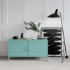 A teal metal cabinet with a black floor lamp and artwork in a modern living room setting. Voir les images du produit
