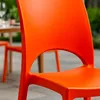 Close-up of an orange chair with a table and other chairs blurred in the background. Voir les images du produit