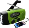 A green and black emergency radio with a flashlight and a smartphone charging. Produktbild-Vorschau