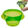 Grüne durchsichtige Plastik-Salatschleuderschüssel mit einer kleineren klaren Schüssel darüber, Hände halten Salat Anteprima dell’immagine prodotto