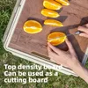 A person is cutting oranges on a wooden cutting board, which is part of a camping box. Produktbild-Vorschau