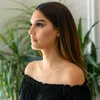 A woman wearing a black off-the-shoulder top, with a gold necklace visible. Produktbild-Vorschau