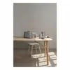 A modern kitchen scene with a grey toaster and accessories on a wooden table, with a chair in the background. Náhled obrázku produktu