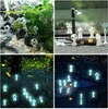 A collage of four images showing small white figures in different settings, including a natural environment, a car dashboard, and a dark forest with fireflies. Produktbild-Vorschau
