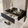 A black wall-mounted nightstand with a drawer open, displaying a book. Decorative items and cosmetics are on top. Produktbild-Vorschau