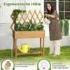 A woman is watering plants in a raised garden bed with a trellis. The scene is outdoors on a grassy area. Produktbild-Vorschau