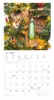 A cat peeking out from a Christmas tree with a calendar below. Produktbild-Vorschau