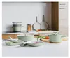 A collection of sage green cookware is displayed on a kitchen counter. Podgląd zdjęcia produktu