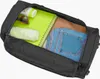 An open black duffel bag with various travel items inside. Produktbild-Vorschau