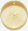 A close-up of a drop of golden liquid with small bubbles. Voir les images du produit