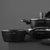 A set of black cookware, including pots and pans, is displayed against a dark gray background. Produktbild-Vorschau