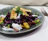 A close-up of a salad with grilled cheese on a plate. Produktbild-Vorschau