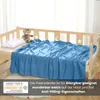 A blue fleece blanket is laid out on a wooden crib, with a teddy bear and a pillow. Náhľad obrázku produktu