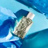 A bottle of Eau de Rochas perfume is placed on a blue background with crumpled blue paper. Produktbild-Vorschau