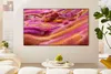 A modern living room with a large TV displaying a colorful abstract image. Voir les images du produit