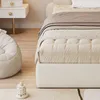A close-up view of a bed and a nightstand in a bedroom. Voir les images du produit