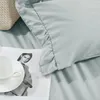 A close-up view of bedding with a cup and a magazine. Produktbild-Vorschau